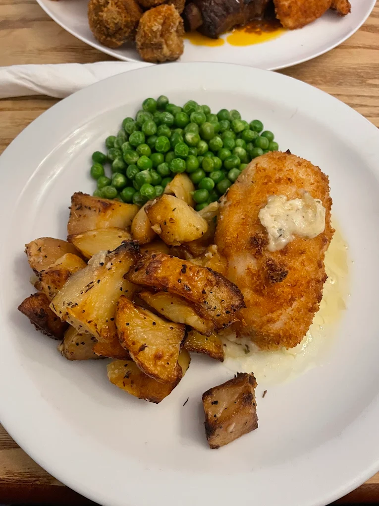 Chicken Kiev with roast potatoes and peas