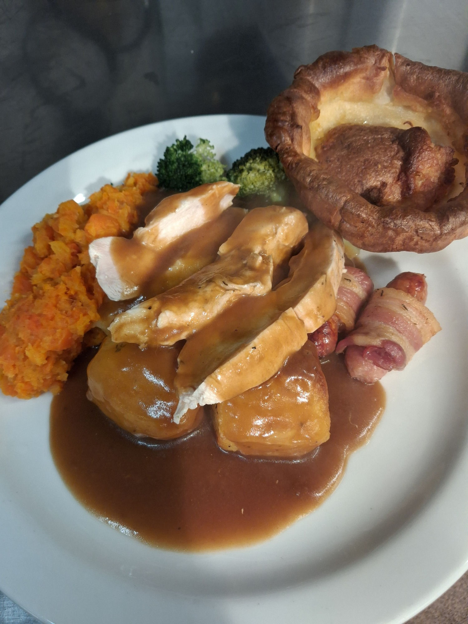 Roast chicken dinner with Yorkshire pudding, pigs in blankets, vegetables and gravy